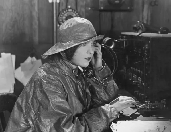 Woman in raincoat sending message in Morse code