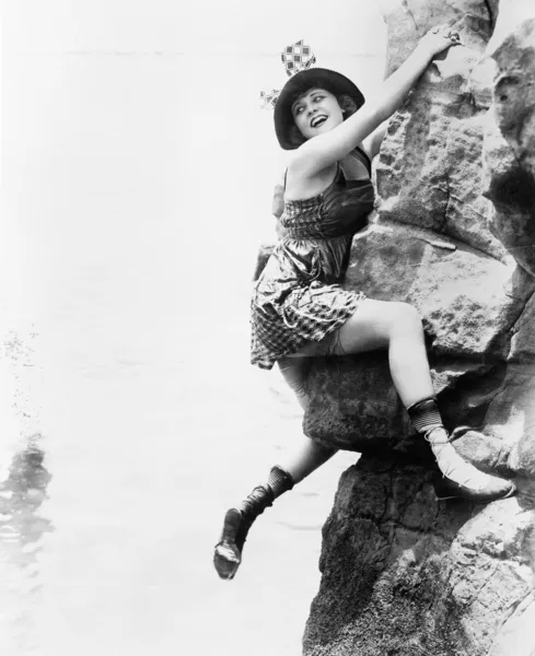 Portrait of woman climbing rock cliff