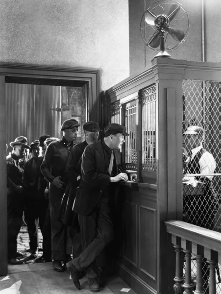 Men waiting in line to place bets