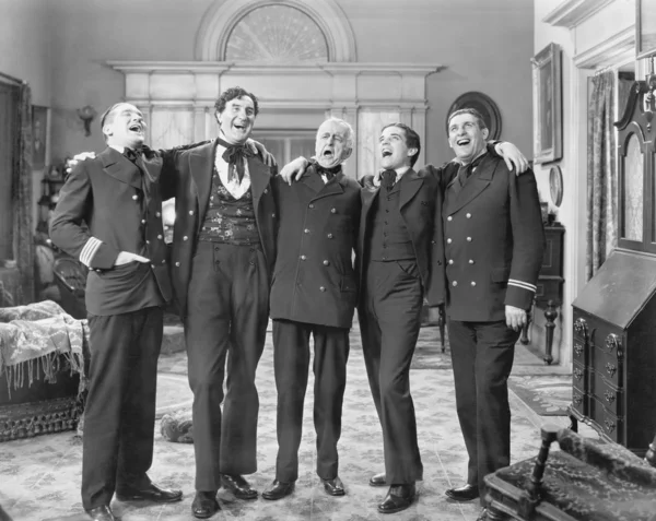 Five men standing together singing