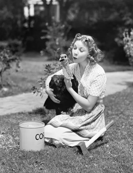 Young woman, with an ax next to her, hugs a turkey