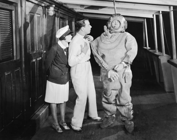 Two looking in shock at a diver in a divers suit