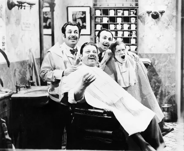 Group of four men at a barber shop singing