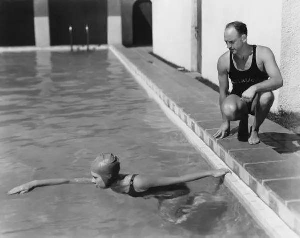 Instructor teaching woman how to swim