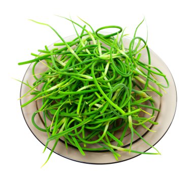 Fresh garlic scapes on plate clipart