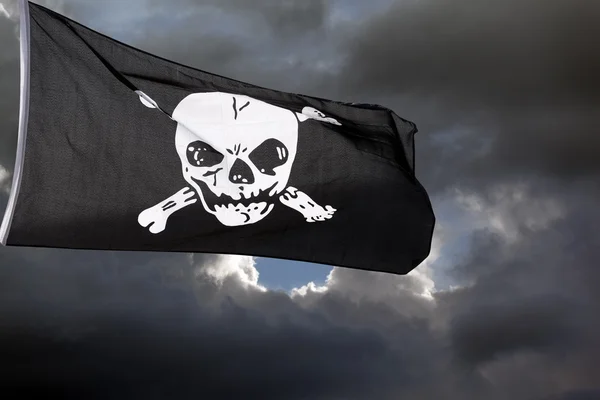 Jolly Roger (bandera pirata) contra nubes de tormenta — Foto de Stock