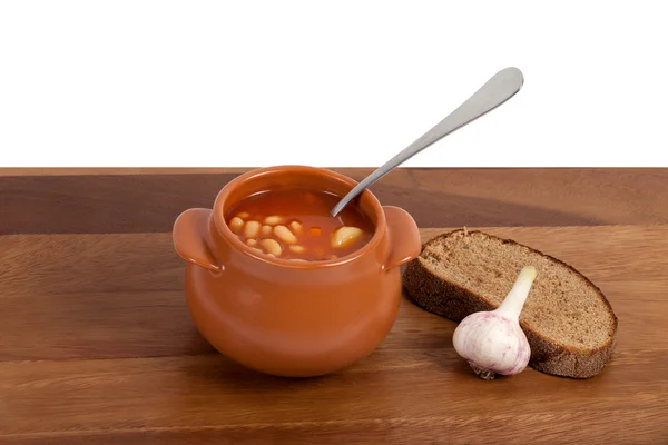 Soup in ceramic pot with bread and garlic — Stock Photo, Image