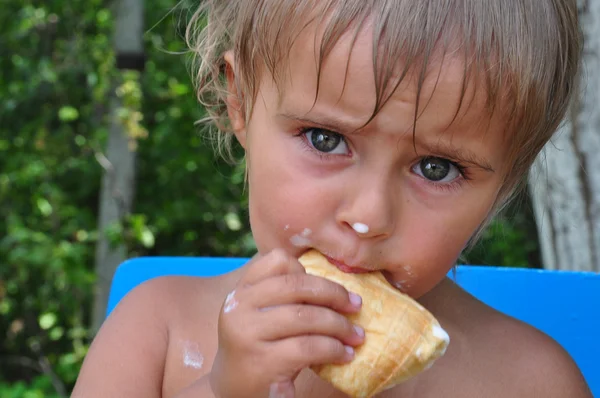Kind isst schmelzendes Eis — Stockfoto
