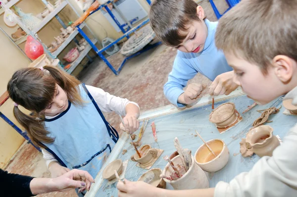 stock image Group of children shaping clay in pottery studio