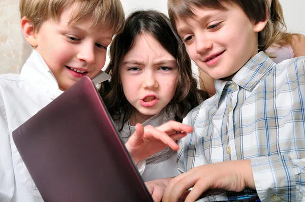 Grupo de niños amigos jugando a estudiar en el portátil —  Fotos de Stock