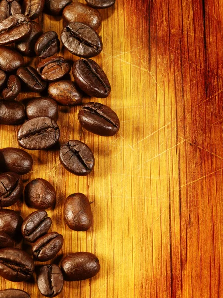 Kaffebönor på trä skrivbordet som mat bakgrund — Stockfoto