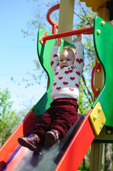 Kleines Mädchen rutscht auf Spielplatz — Stockfoto