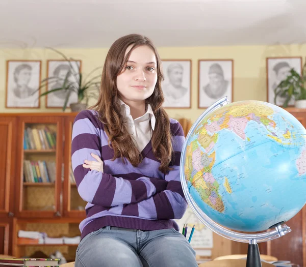 Söt flicka med världen i klassrummet — Stockfoto