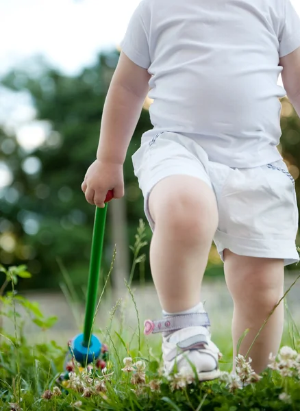 Litet barn gå i grönt gräs — Stockfoto