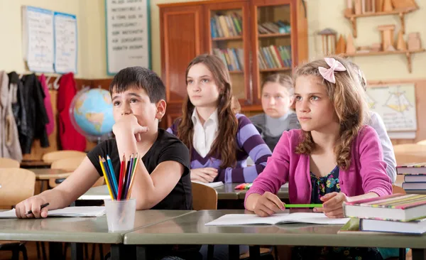 Schoolchildren at classroom during a lesson — Stock Photo, Image