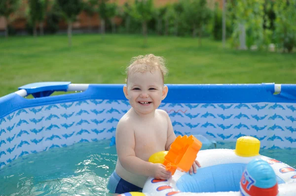 Curly haired girl in backyard pool — Stock Photo, Image