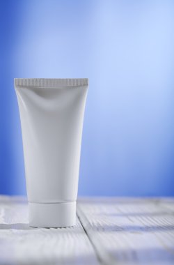 White tube on the table and blue background clipart