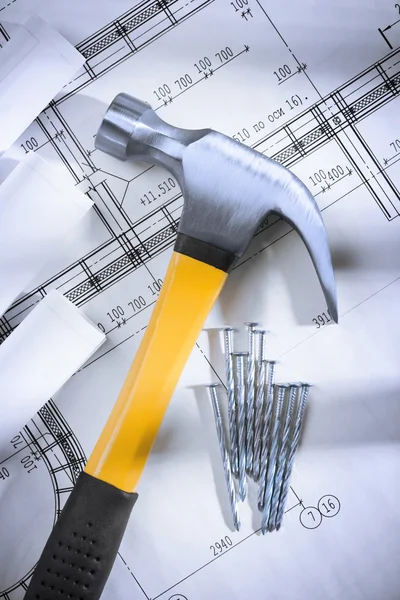 Claw hammer and nails with blueprints — Stock Photo, Image