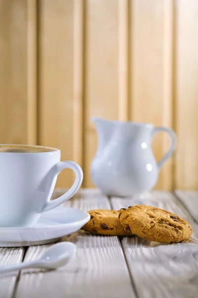 Καφέ στο φλιτζάνι και cookie, μπολ γάλα στο λευκό παλιό τραπέζι — Φωτογραφία Αρχείου
