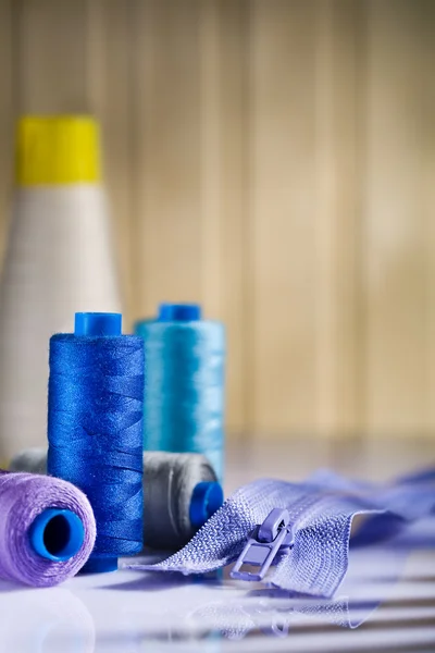 Sewing spools and zip on table — Stock Photo, Image