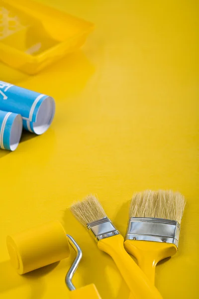 Инструмент покраски на желтом столе — стоковое фото