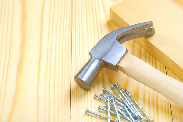 Hammer med naglar och planka — Stockfoto