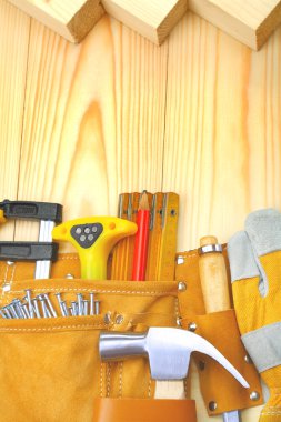 Construction tools in belt on wooden boards clipart