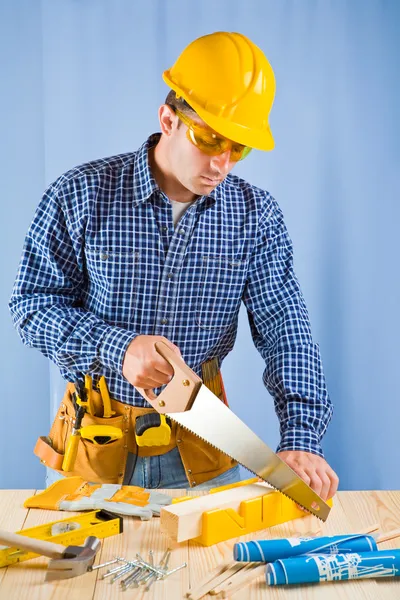 Carpenter works with handsaw Royalty Free Stock Images