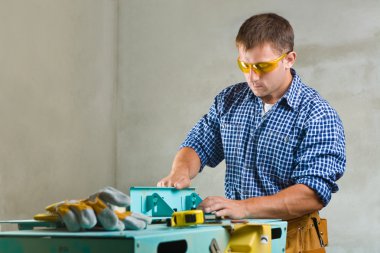 Worker prepares the woodworking mashine to work clipart