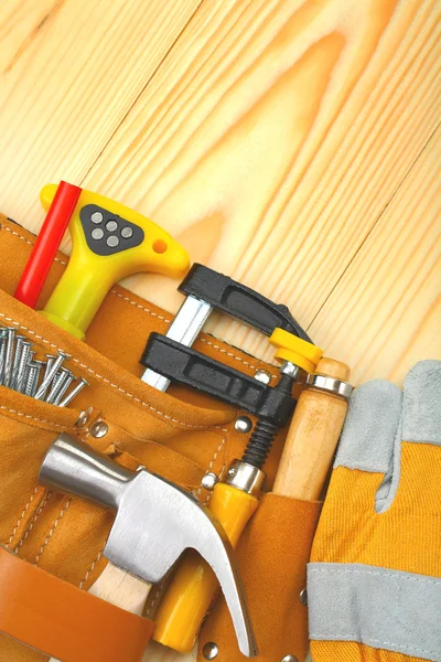 Werkzeuge im Gürtel auf Holzbrettern — Stockfoto