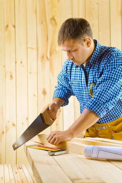 Carpenter cuts the plank — Stock Photo, Image