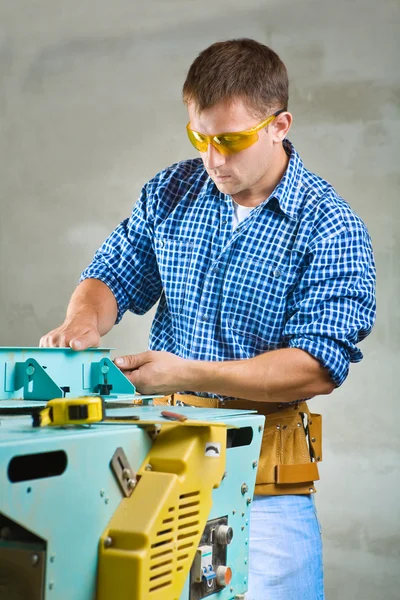 Junge Männer stellen Holzbearbeitungsmaschine ein — Stockfoto