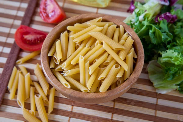 Неприготовленные итальянские макароны в миске — стоковое фото