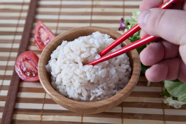 Hand holds chopstick with rice — Stock Photo, Image