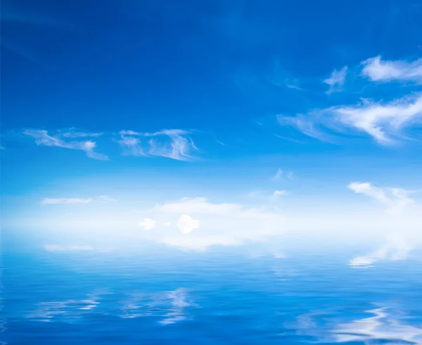 Weiße, flauschige Wolken mit Regenbogen am blauen Himmel — Stockfoto
