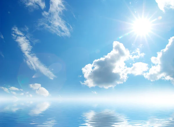 Білі пухнасті хмари з веселкою на блакитному небі — стокове фото
