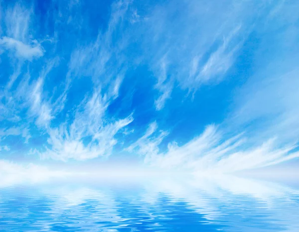 Białe puszyste chmury z rainbow na niebieskim niebie — Zdjęcie stockowe