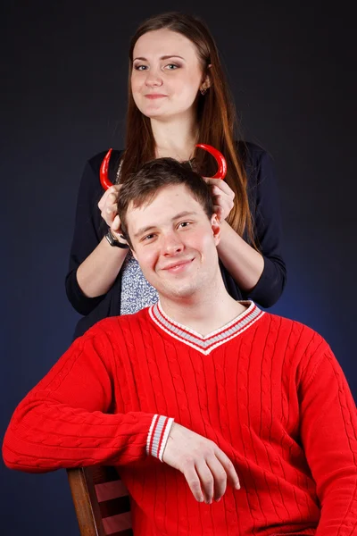 Beautiful girl with young man with red horns made of pepper — Stock Photo, Image