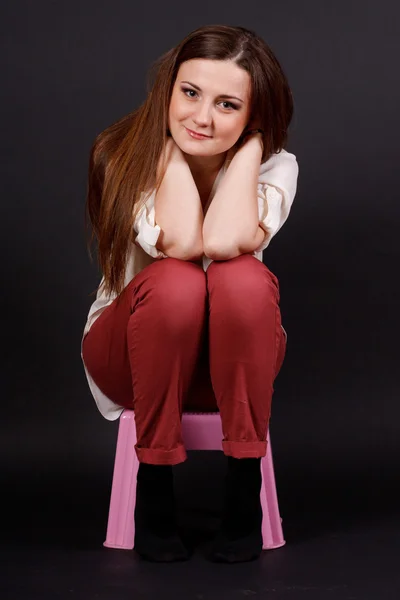 Dziewczyna z miękkich zabawek siedzi na krześle — Zdjęcie stockowe