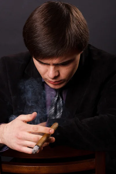 Jovem empresário fumando um charuto — Fotografia de Stock