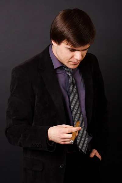 Jovem empresário fumando um charuto — Fotografia de Stock