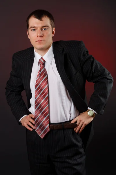 Stilig ung affärsman står på svart bakgrund — Stockfoto
