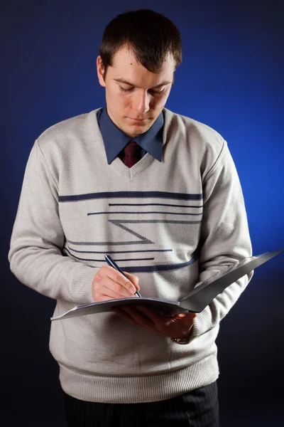 Porträtt av stilig ung man läser ett kontrakt — Stockfoto