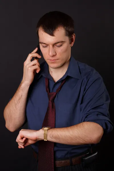 Affärsman på telefonen tittar på sin klocka — Stockfoto