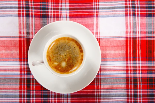 Taza de café sobre un mantel rojo —  Fotos de Stock
