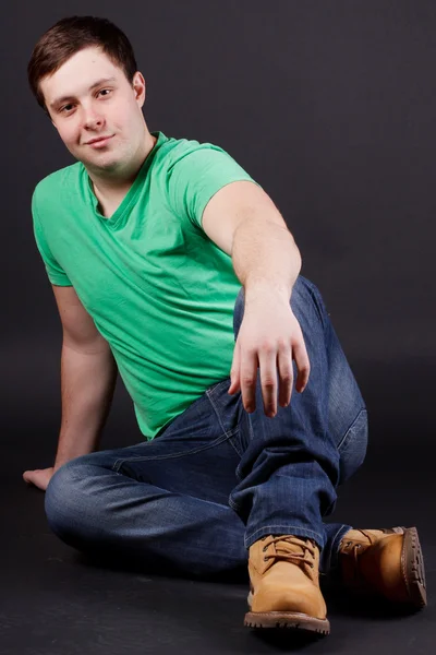 A young man sitting on the floor Stock Image