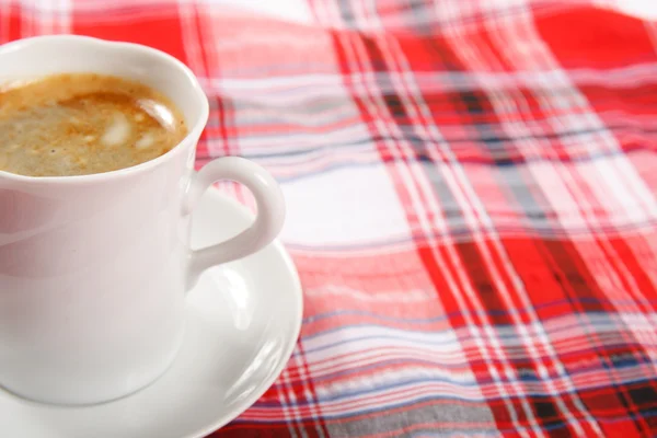 Xícara de café em uma toalha de mesa vermelha Imagens Royalty-Free