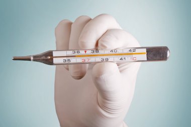 El ve gri arka plan üzerinde bir termometre (36 C)