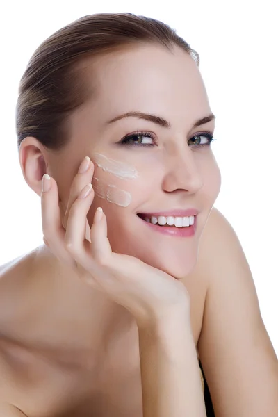 Feliz sonrisa hermosa mujer aplicando crema hidratante en la cara —  Fotos de Stock