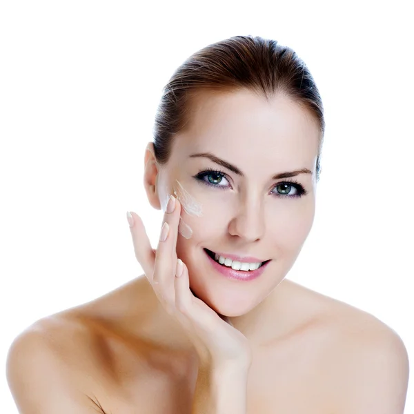 Felice sorridente bella donna applicando crema idratante sul viso Foto Stock Royalty Free